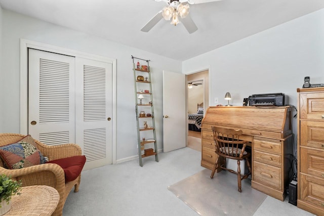 office area with a ceiling fan and light colored carpet