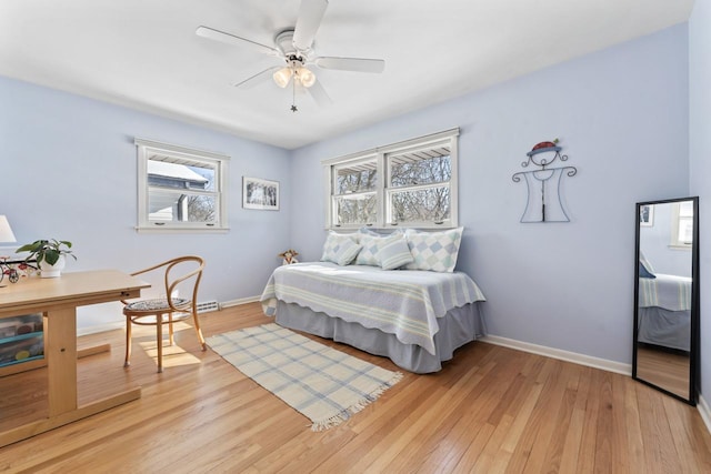 bedroom with light wood finished floors, a ceiling fan, and baseboards