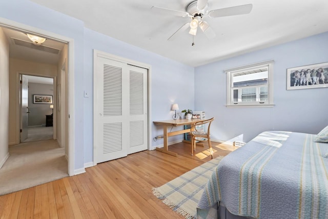 bedroom with baseboards, a closet, a ceiling fan, and light wood-style floors