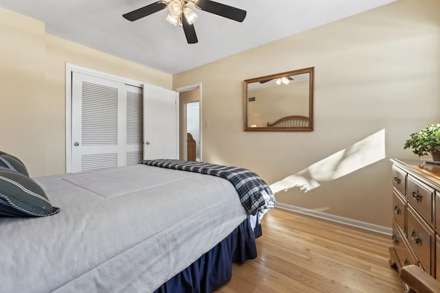 bedroom featuring light wood-type flooring, a closet, ceiling fan, and baseboards