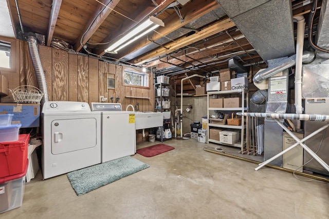 below grade area with washer and clothes dryer, a sink, and wooden walls