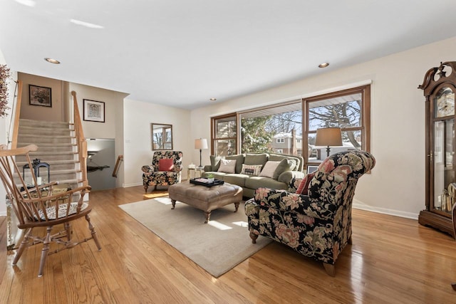 living area with light wood finished floors, baseboards, stairway, and recessed lighting