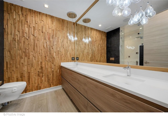 bathroom with wooden walls, vanity, wood-type flooring, toilet, and walk in shower