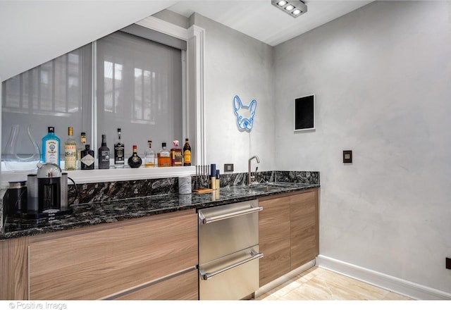 bar with dark stone countertops and sink