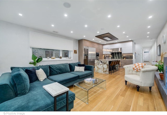 living room featuring sink and light hardwood / wood-style flooring