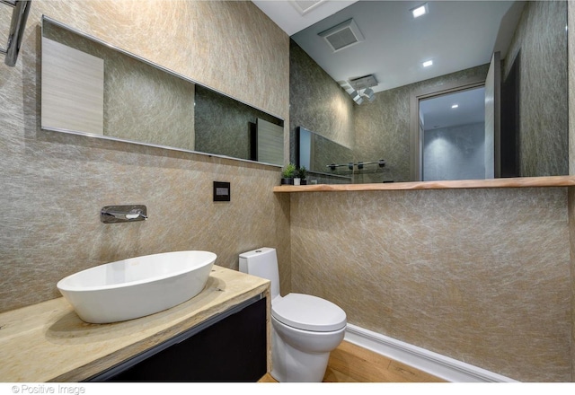 bathroom with vanity, hardwood / wood-style floors, and toilet