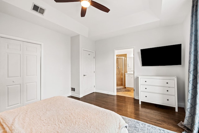 bedroom with baseboards, visible vents, dark wood-style flooring, ensuite bathroom, and a closet