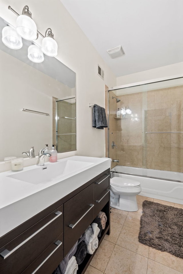 bathroom with visible vents, bath / shower combo with glass door, toilet, tile patterned flooring, and vanity