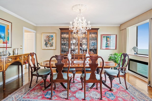 dining area with ornamental molding, hardwood / wood-style floors, and a chandelier