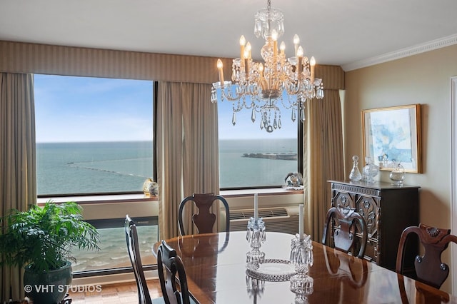 dining room featuring crown molding, a chandelier, and a water view