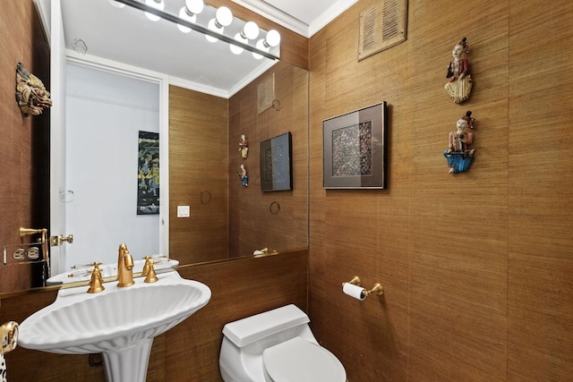 bathroom with ornamental molding, toilet, and sink