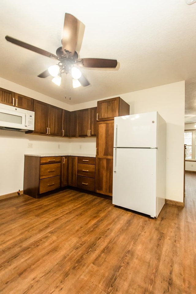 kitchen with ceiling fan, white appliances, and light hardwood / wood-style flooring