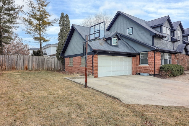 view of side of home featuring brick siding, a yard, fence, a garage, and driveway