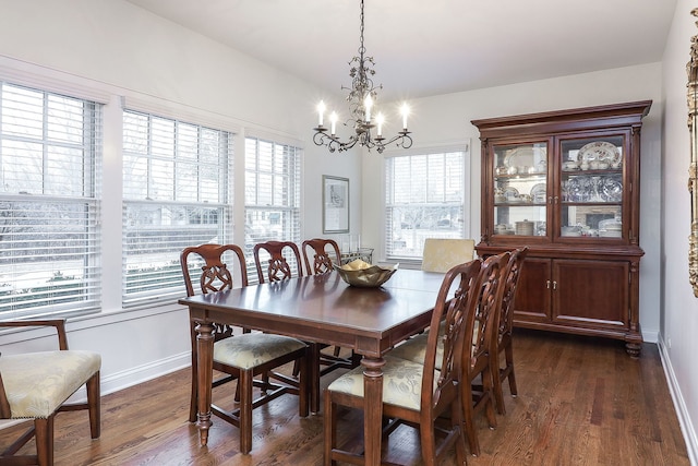 dining room with a chandelier, dark wood-style flooring, and baseboards