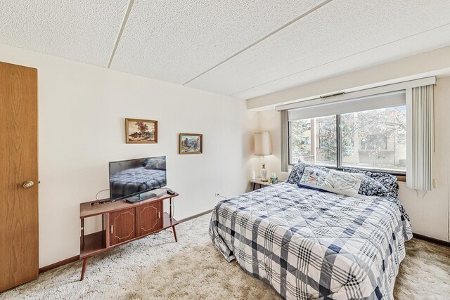 bedroom with a textured ceiling, baseboards, and carpet flooring