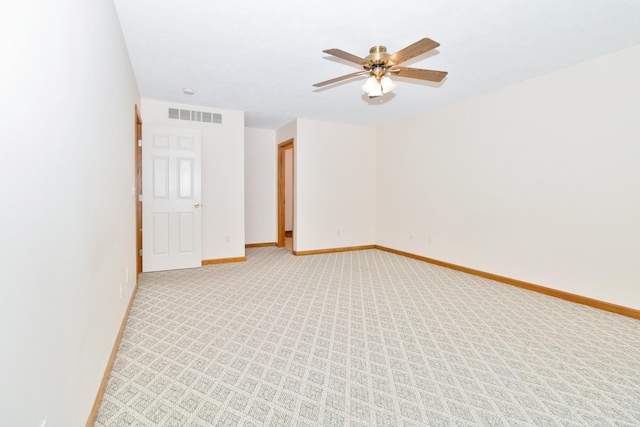 unfurnished room with light carpet, baseboards, visible vents, and a ceiling fan