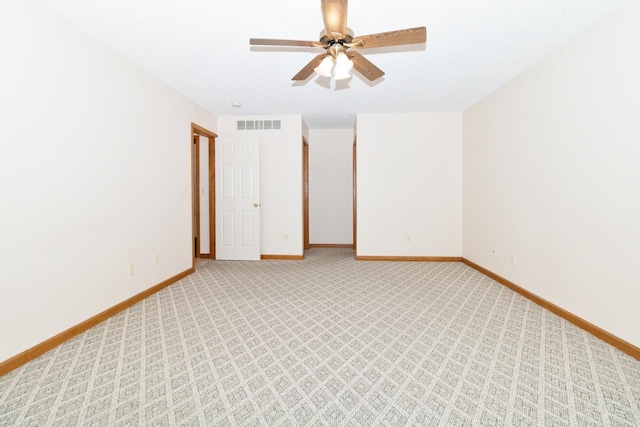 empty room with baseboards, a ceiling fan, visible vents, and light colored carpet