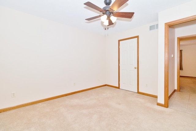 unfurnished bedroom featuring light carpet, baseboards, visible vents, and ceiling fan