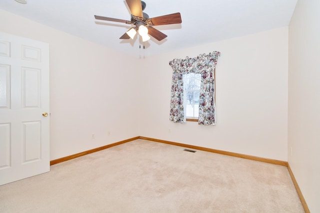 spare room with baseboards, visible vents, ceiling fan, and carpet flooring