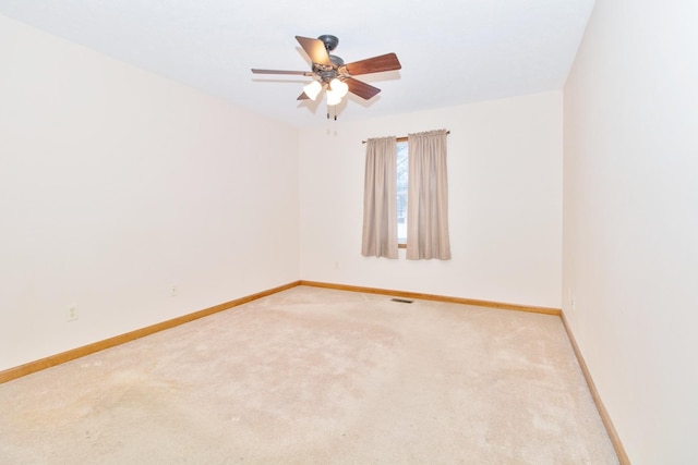 empty room with light carpet, visible vents, baseboards, and a ceiling fan