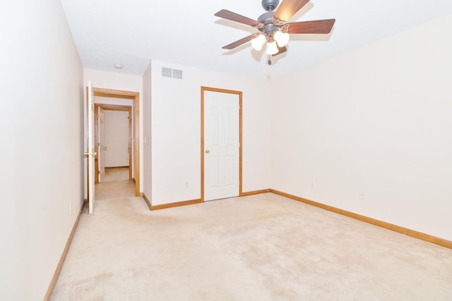 unfurnished bedroom with a ceiling fan, visible vents, light carpet, and baseboards