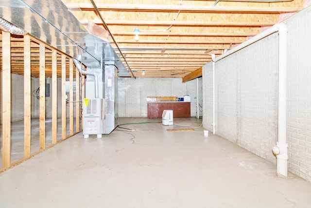 unfinished basement with brick wall and heating unit