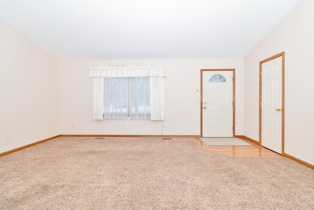 interior space featuring baseboards, vaulted ceiling, and light colored carpet