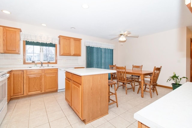 kitchen with white appliances, a kitchen island, a kitchen bar, a sink, and light tile patterned flooring