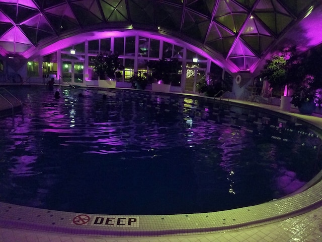 view of pool at twilight