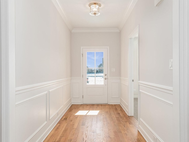 doorway with crown molding and light hardwood / wood-style flooring