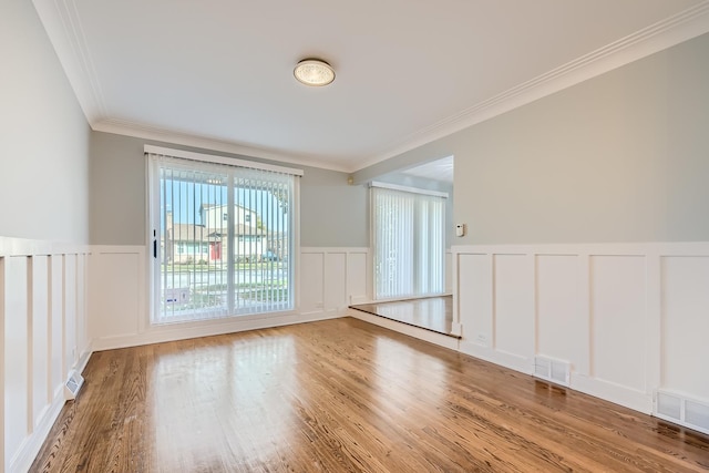 unfurnished room with crown molding and hardwood / wood-style flooring