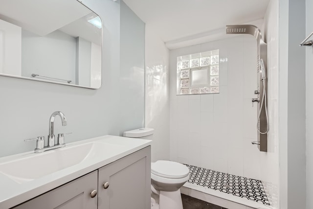 bathroom featuring tiled shower, vanity, and toilet