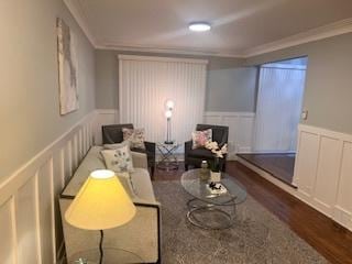 living area with ornamental molding and dark hardwood / wood-style floors