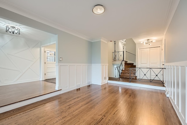 unfurnished living room featuring hardwood / wood-style flooring and crown molding