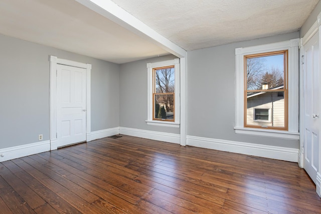 empty room featuring dark wood finished floors and baseboards