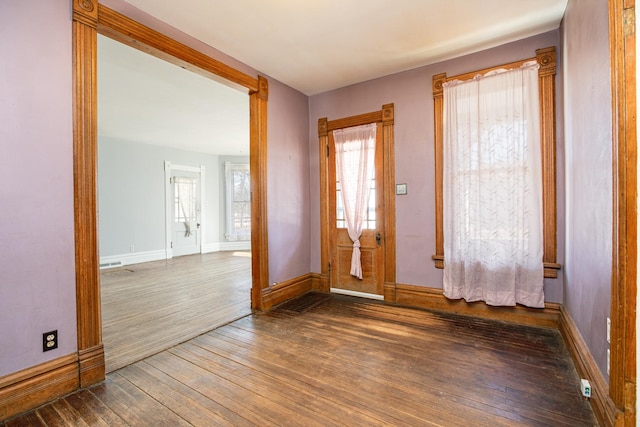 foyer entrance featuring wood-type flooring and baseboards