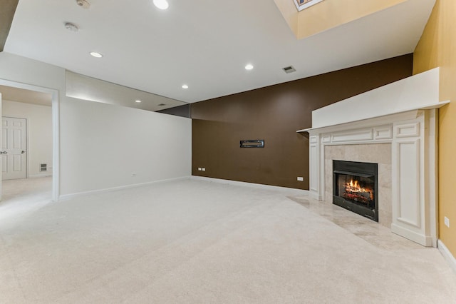 unfurnished living room with light carpet, a skylight, and a high end fireplace