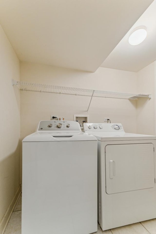 clothes washing area featuring light tile patterned floors and independent washer and dryer