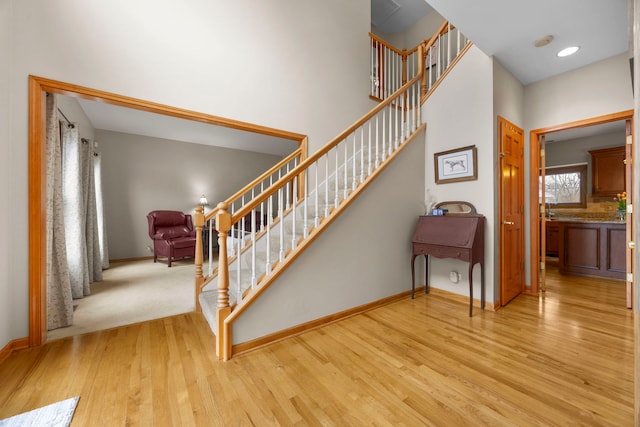 staircase with baseboards and wood finished floors