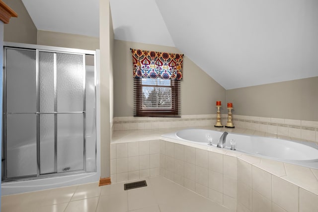 full bathroom featuring tile patterned floors, lofted ceiling, a garden tub, and a shower stall