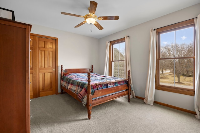 bedroom with light colored carpet, baseboards, and ceiling fan