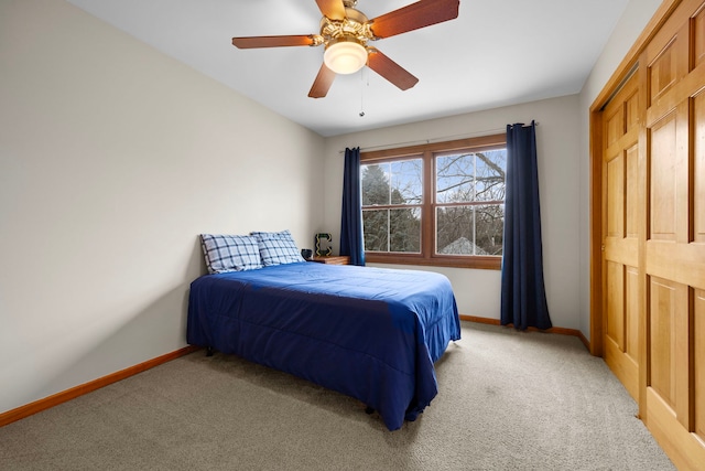 bedroom featuring baseboards, light carpet, and ceiling fan