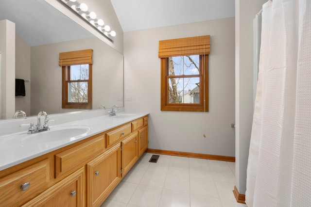 bathroom featuring vaulted ceiling, plenty of natural light, and a sink