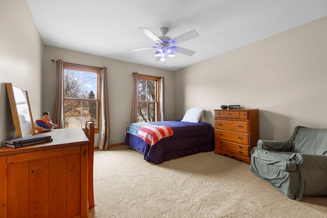 bedroom featuring light colored carpet and a ceiling fan