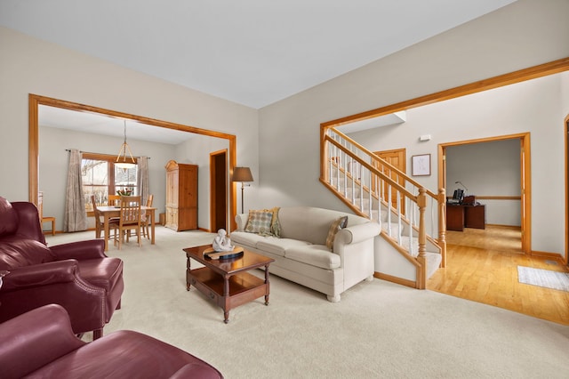 carpeted living room featuring stairway and baseboards