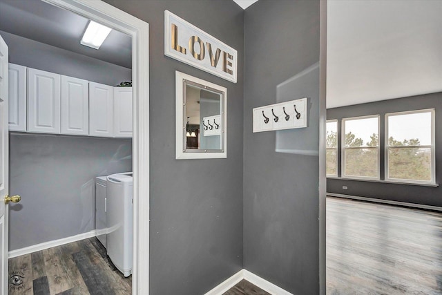washroom featuring washer and clothes dryer, cabinet space, baseboards, and wood finished floors