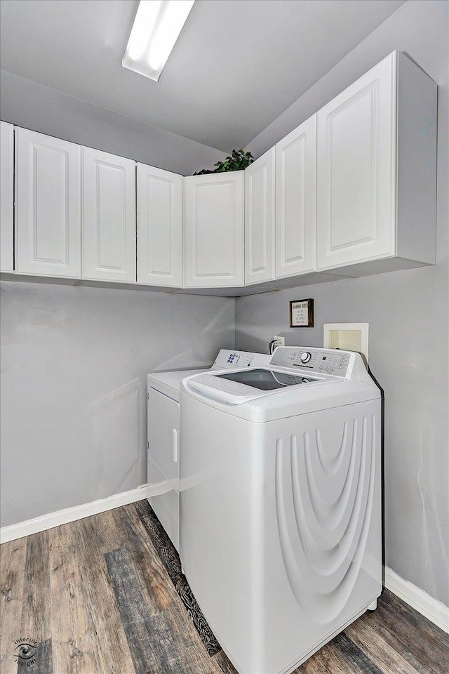 laundry room with baseboards, cabinet space, separate washer and dryer, and dark wood-style floors