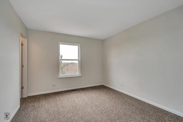 unfurnished room featuring carpet and baseboards