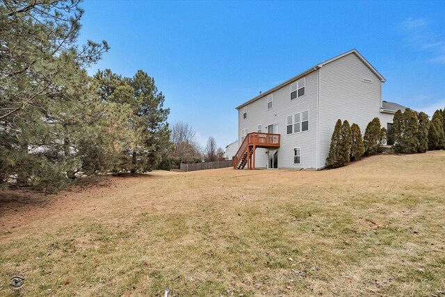 rear view of house featuring stairs, a deck, a yard, and fence