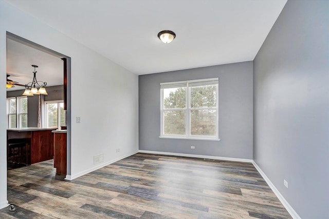 empty room with visible vents, baseboards, and dark wood finished floors